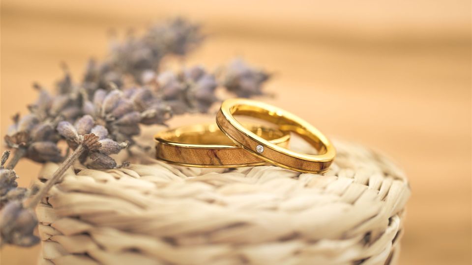 Ringe in Gold mit Olivenholz neben Lavendelblüten